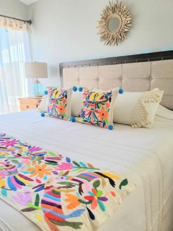 sypialnia zaprojektowana przez solunę paz ma haft otomi na kocu i parę poduszek