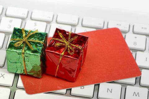 Świąteczne zakupy online - miniaturowe pudełka upominkowe oraz karta kredytowa lub upominkowa na klawiaturze komputera.