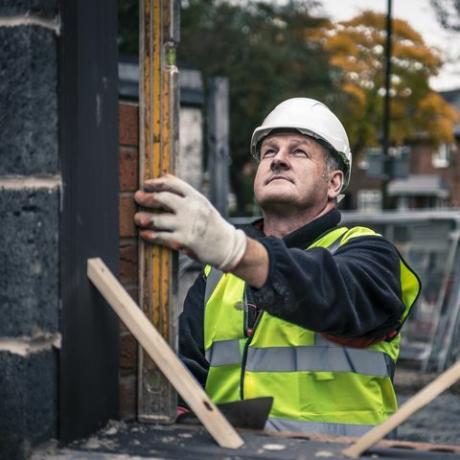 pracownicy kłaść cegły na budowie