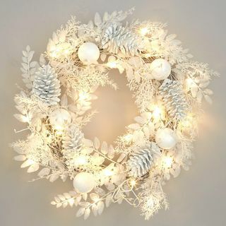 Wstępnie oświetlony zimowy biały wieniec bożonarodzeniowy