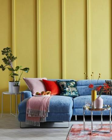 jasny salon z żółtą boazerią i niebieską sofą