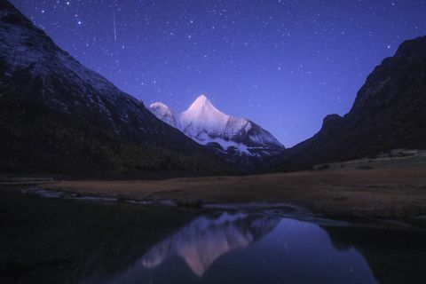 meteor orionidowy spływa nad śnieżną górą Jampayang w Chinach