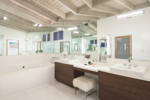 nowoczesna łazienka z brązowymi szafkami i dużym lustrem