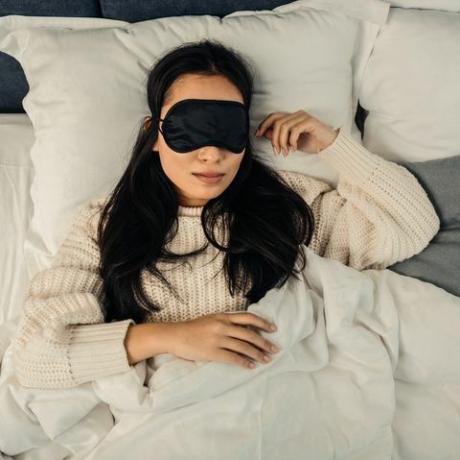 ciemnowłosa kobieta czuje się zrelaksowana podczas snu
