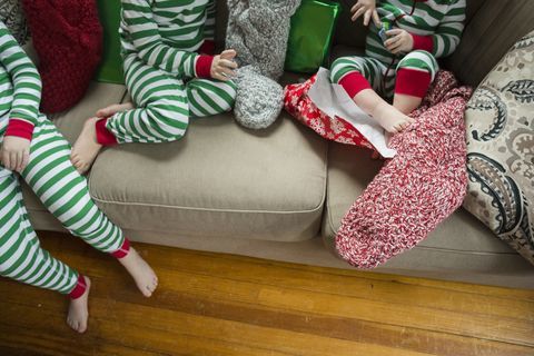 Bez twarzy strzał rodzeństwa otwierającego pończochy w domu na Boże Narodzenie