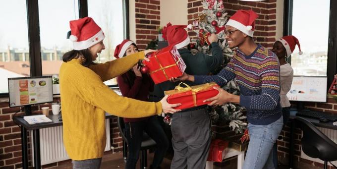 zróżnicowana grupa współpracowników wymieniających prezenty świąteczne
