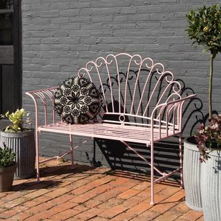 Ładna różowa metalowa ławka ogrodowa