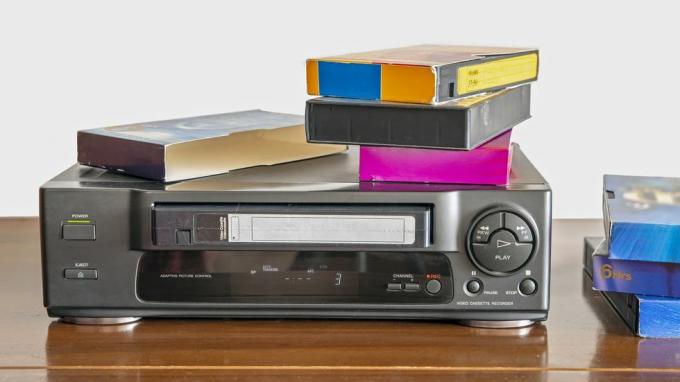 stary odtwarzacz kaset wideo ze starymi kasetami wideo na drewnianej szafce